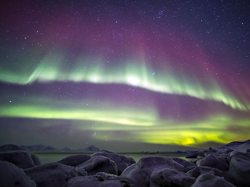 The Northern Lights over an Arctic fjord