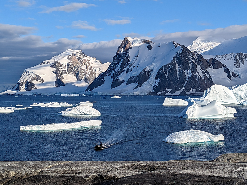 Zodiac making its way to shore back-dropped by rugged landscape